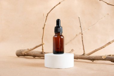 Komik kehribar cam şişeler ve pastel arka planda kuru ahşap dallar. Cilt bakım ürünleri ambalaj tasarımı. Spa konsepti.