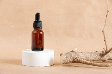 Komik kehribar cam şişeler ve pastel arka planda kuru ahşap dallar. Cilt bakım ürünleri ambalaj tasarımı. Spa konsepti.