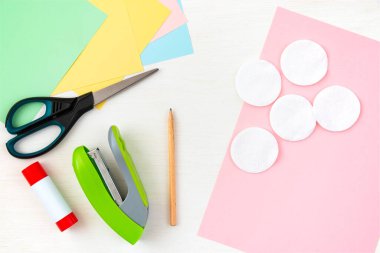 Renkli kağıt, makas, pamuk pedleri, makas, zımba, beyaz masa üzerindeki kalem. Anneler Günü için çocuk el işi. Adım adım talimat veriyorum. Adım 1.