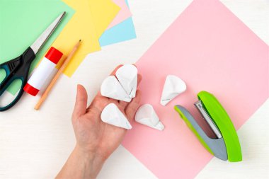 Pamuklu yapraklar. Renkli kağıt, zımba, makas, makas, beyaz masadaki kalem. Anneler Günü için çocuk el işi. Adım adım talimat veriyorum. 4. Adım.