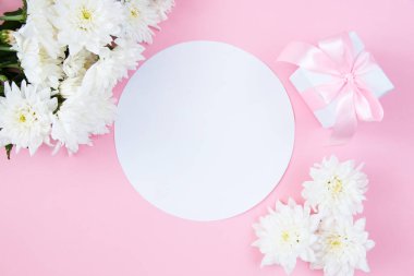 Pembe pastel arka planda beyaz çiçekler. Temiz metin alanı olan şenlikli çiçek konsepti. Düz yatıyordu. Yukarıdan görüntüle.