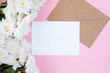 Pembe pastel arka planda beyaz çiçekler. Temiz metin alanı olan şenlikli çiçek konsepti. Düz yatıyordu. Yukarıdan görüntüle.