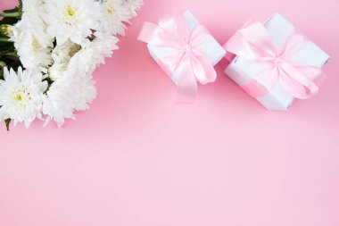 Pembe pastel arka planda beyaz çiçekler. Temiz metin alanı olan şenlikli çiçek konsepti. Düz yatıyordu. Yukarıdan görüntüle.