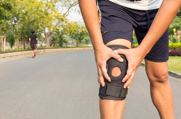 Close up of knee support brace on leg at public park — Stock Photo, Image