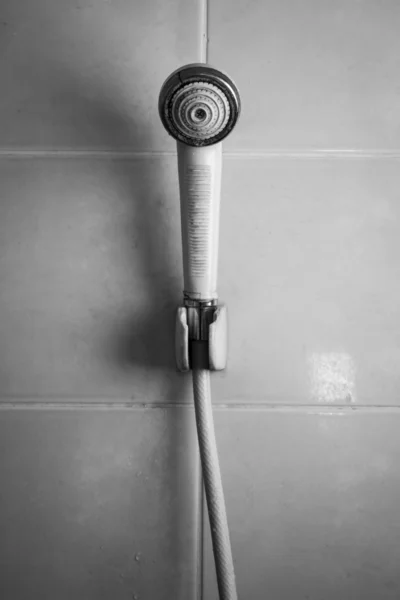Black and white shower head hanging on tile wall — Stock Photo, Image