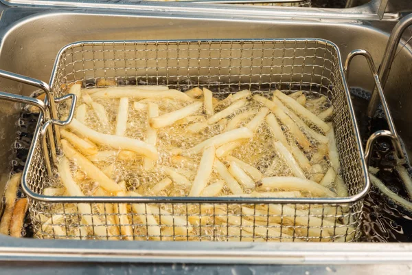 French fries in deep fryer — Stock Photo, Image