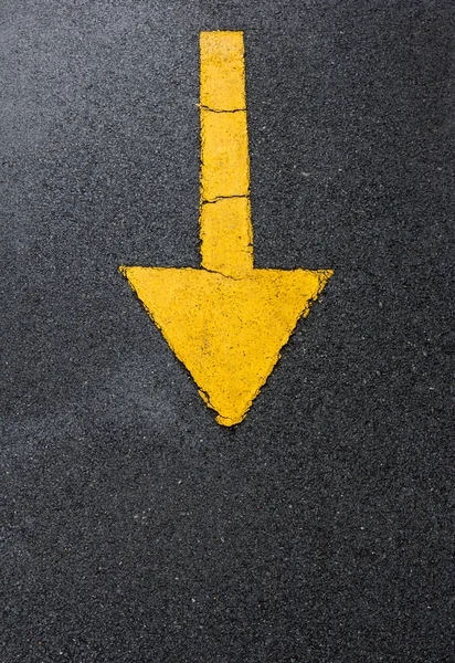 Yellow arrow down on asphalt street — Stock Photo, Image