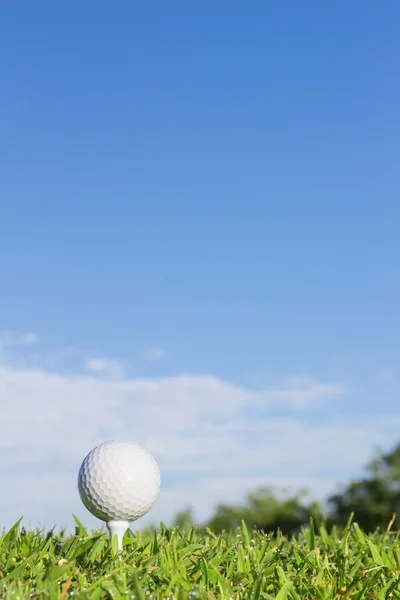 Pelota de golf en una camiseta con fondo de cielo — Foto de Stock
