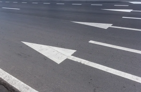 Freccia segno su strada asfaltata — Foto Stock