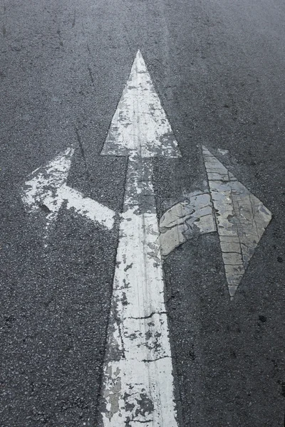 Three arrows sign on asphalt road — Stock Photo, Image