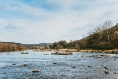 Nehir ve ormanı olan güzel bir sonbahar manzarası. Sonbaharda. İnanılmaz bulutlu gökyüzü.