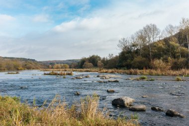 Nehir ve ormanı olan güzel bir sonbahar manzarası. Sonbaharda. İnanılmaz bulutlu gökyüzü.
