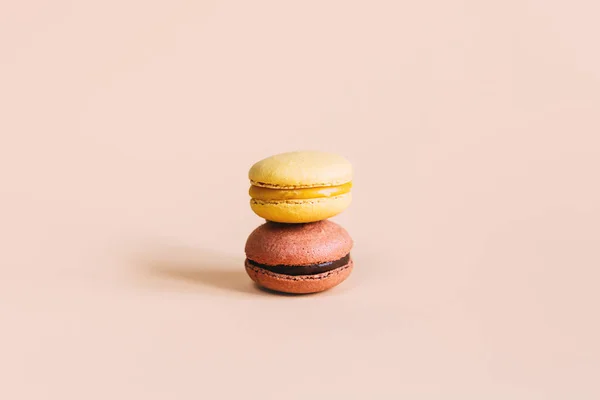 Tasty french macaroons on a pink pastel background. Place for text.
