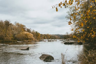 Nehir ve ormanı olan güzel bir sonbahar manzarası. Sonbaharda. İnanılmaz bulutlu gökyüzü.