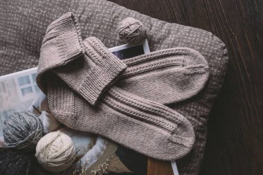 İplik toplarıyla örülmüş bir çift çorap. Doğal renkler. Koyu kırsal ahşap arkaplan. 