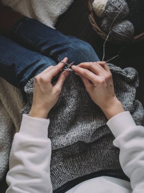 El örgüsü, iğneler ve iplik yumakları olan bir kadın. El yapımı ve yavaş yaşam için higge kavramı. 