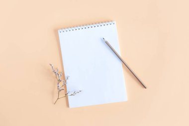 Sarı arka planda boş sayfa ve kalem olan defter. Düz yatıyordu. Metin için yer. 