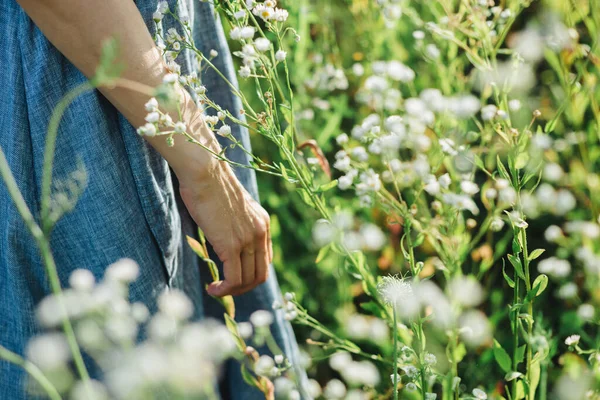 太陽の光の下で夏の牧草地に野花の束を持つライトブルーのリネンのドレスの女の子 夏の背景 — ストック写真