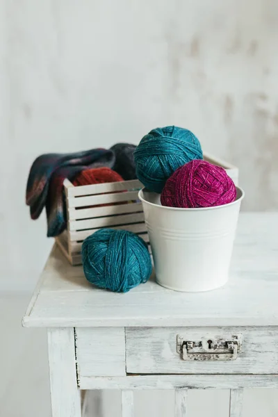 白い木の背景に糸玉で編んだ靴下を手で編む 手作りと巨大なスローライフのための概念 — ストック写真