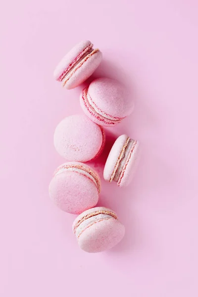 Pembe pastel arka planda lezzetli Fransız kurabiyeleri. Metin için yer.