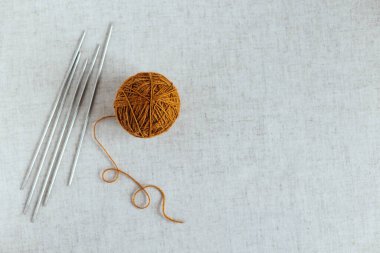 Örgü örmek için iplik yumağı ve iğneler. El yapımı ve yavaş ev hayatı için arka plan. Metin için yer.