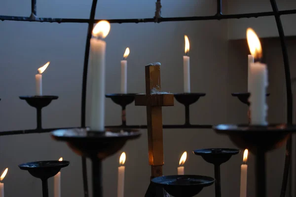 Karanlık bir iç mekânda bir haçı çevreleyen mumlar. İnanç, maneviyat, dua, umut, hatıra ve iç huzur kavramı. Sıcak mum ışığı sakin ve düşünceli bir atmosfer yaratıyor.