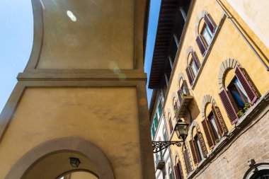 Floransa, İtalya 'daki binaların mimari bir görüntüsü bulutsuz bir yaz gününde kemerli pencereleri büyük kepenklerle gösteriyor.. 