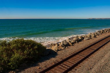 Bulutsuz bir günde Güney Kaliforniya 'nın batı kıyısına paralel giden demiryolu rayları. İzler Pasifik Okyanusuna bakıyor.. 