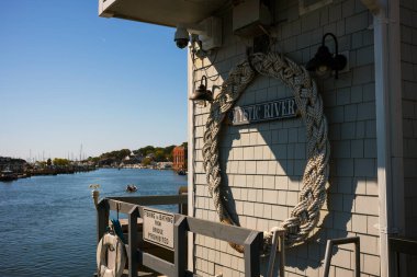 Mistik Nehir 'in sularında küçük bir tekne geziniyor, Mystic' te, CT 'de, New England' da, Mystic River Bascule Köprüsü 'nden görülebilen, açık gökyüzü ile güzel bir sonbahar gününde.. 
