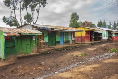 Migori, Kenya, - 17 Haziran 2025: Çalışan ve yaşayan insanların toprak yollarından görülen şehir hayatı. Boş bir mağaza önü .