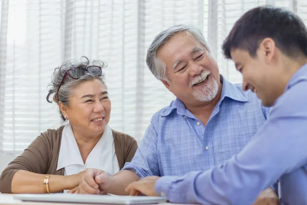 Happy retired Asian senior elderly couple consult with personal financial advisor or real estate agent. Retirement investment planning with professional counseling. Home loan and mortgage concept