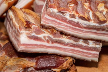 Ahşap bir tahtanın üzerinde domuz pastırması füme.