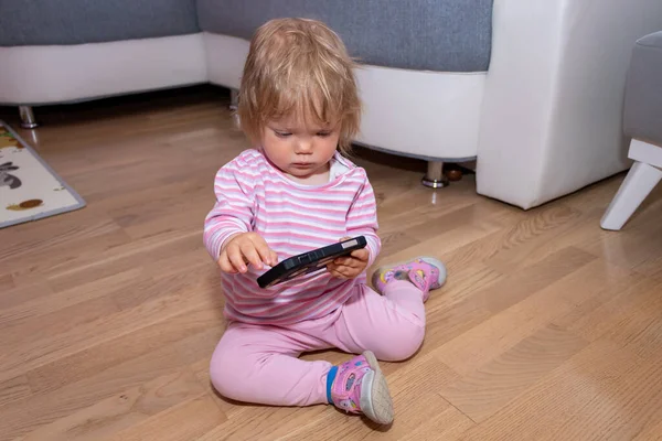 Das Kleine Mädchen Hause Spielt Und Berührt Ein Handy Baby — Stockfoto