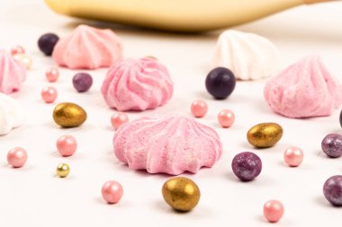 çok renkli dragee şekerler ve beyaz ahşap masaya saçılmış kremalı pasta.