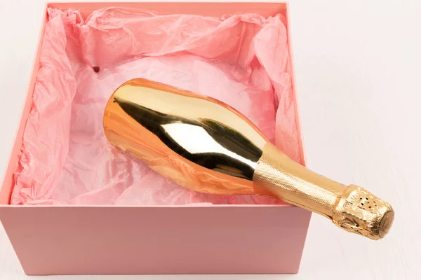 Золотая Бутылка Шампанского Лежит Подарке Розовая Коробка Белом Деревянном Фоне — стоковое фото