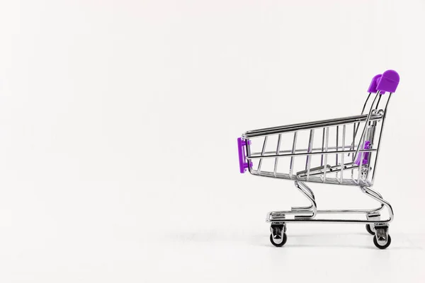 Leere Metall Glänzende Einkaufswagen Auf Rädern Auf Weißem Holztischhintergrund — Stockfoto