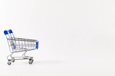 boş metal parlak market arabası beyaz ahşap masa arkasında tekerlekler üzerinde
