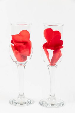 Beyaz ahşap bir masada kırmızı kalpli iki şampanya bardağı. Yakın plan. seçici odak