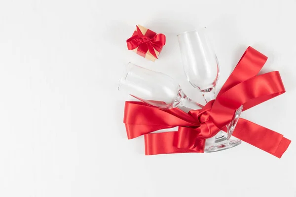 Два Бокала Шампанского Подарочная Коробка Красная Шелковая Лента Белом Деревянном — стоковое фото