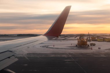 Yekaterinburg 'da. - Rusya. 12/20/2020. Pistin uçak penceresinden ve şafak vakti kalkış sırasında gümüş-kırmızı kanadın bir kısmından manzara. Ural Havayolları. Aeroflot