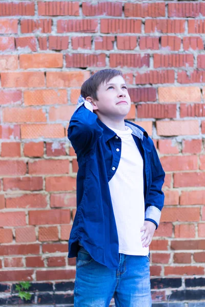 Mavi Tişörtlü Beyaz Tişörtlü Tuğla Duvarlı Arka Planda Bir Çocuk — Stok fotoğraf