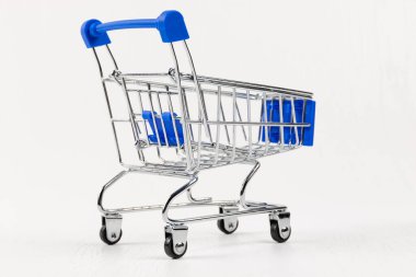 boş metal parlak market arabası beyaz ahşap masa arkasında tekerlekler üzerinde