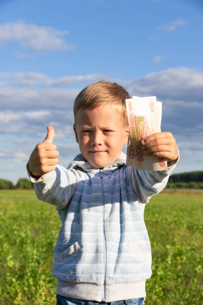 Satisfied Preschooler Child Sweater Holds Paper Rubles Nature Field Background — Stock Photo, Image