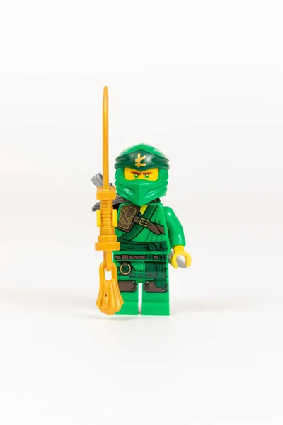 Yekaterinburg 'da. - Rusya. 04.08.2021. Oyuncak kahraman Lloyd yeşil kimonolu ve beyaz arka planda Lego ninjalarının kılıcıyla. Yakın plan. seçici odak