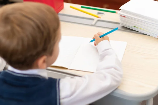 Ragazzo Carino Prima Elementare Uniforme Scolastica Compiti Mentre Seduto Una — Foto Stock