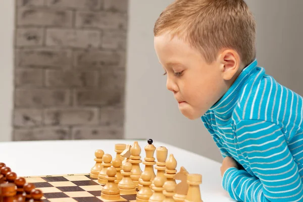 Bonito Menino Sete Anos Jogando Xadrez Casa Uma Mesa Madeira — Fotografia de Stock