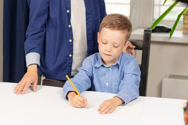 Söt Sjuårig Pojke Som Gör Läxor Hemma Med Mamma Ett — Stockfoto