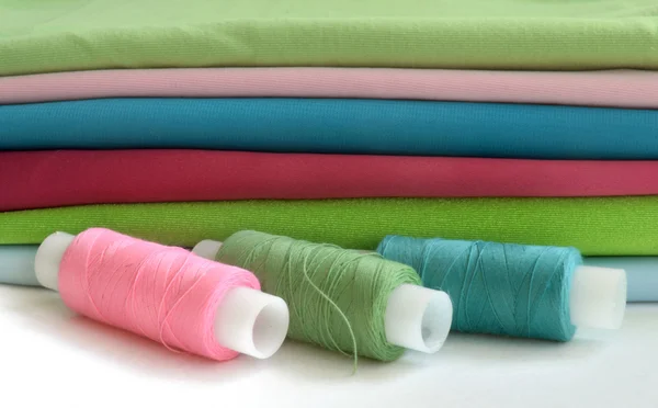 A stack of colorful fabric and thread — Stock Photo, Image