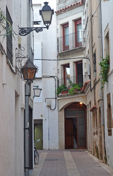 Street lamp hangs above the door to the house on a narrow European street