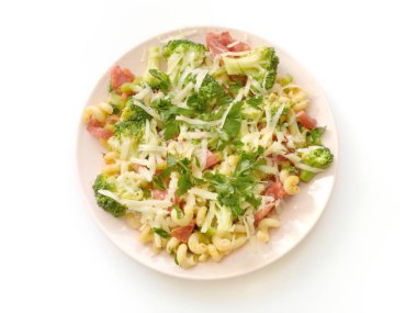 Beyaz arka planda makarna, brokoli, domates ve peynirli yemek.